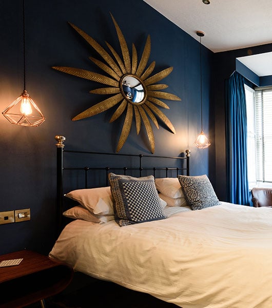 room shot of black iron and brass bed