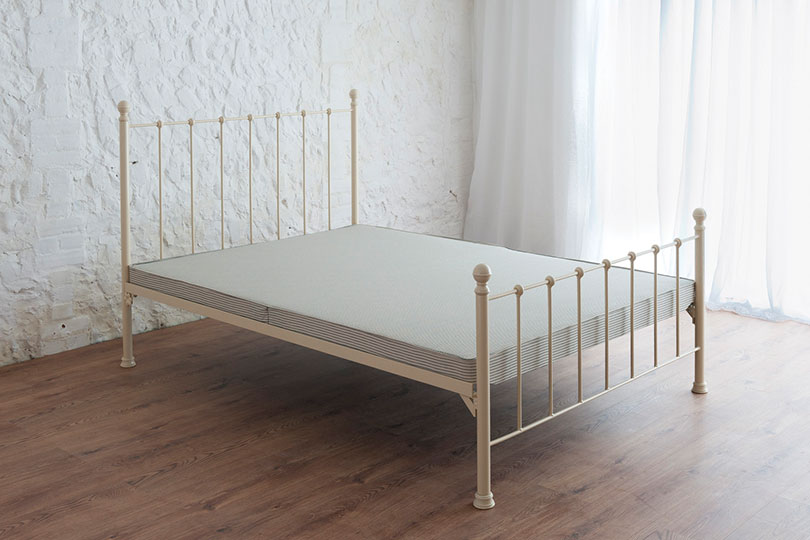 hard top bed base on a metal iron bed frame