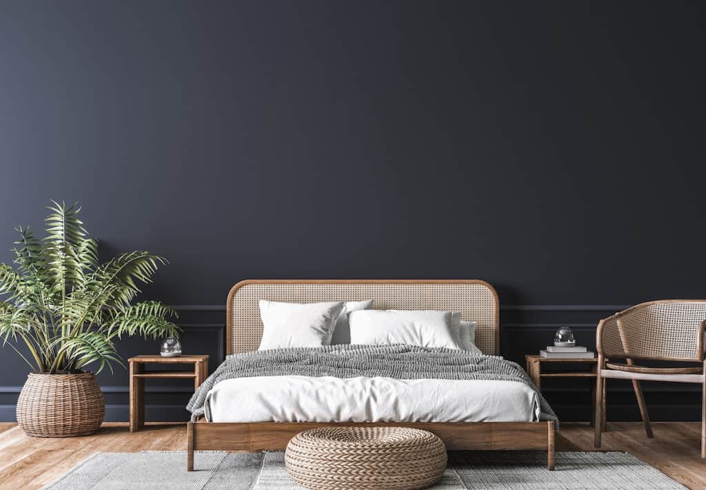 Wooden rattan bed against a dark wall