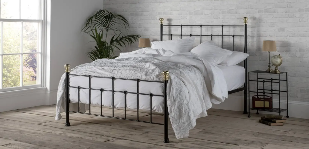 Wrought iron bed with brass finials