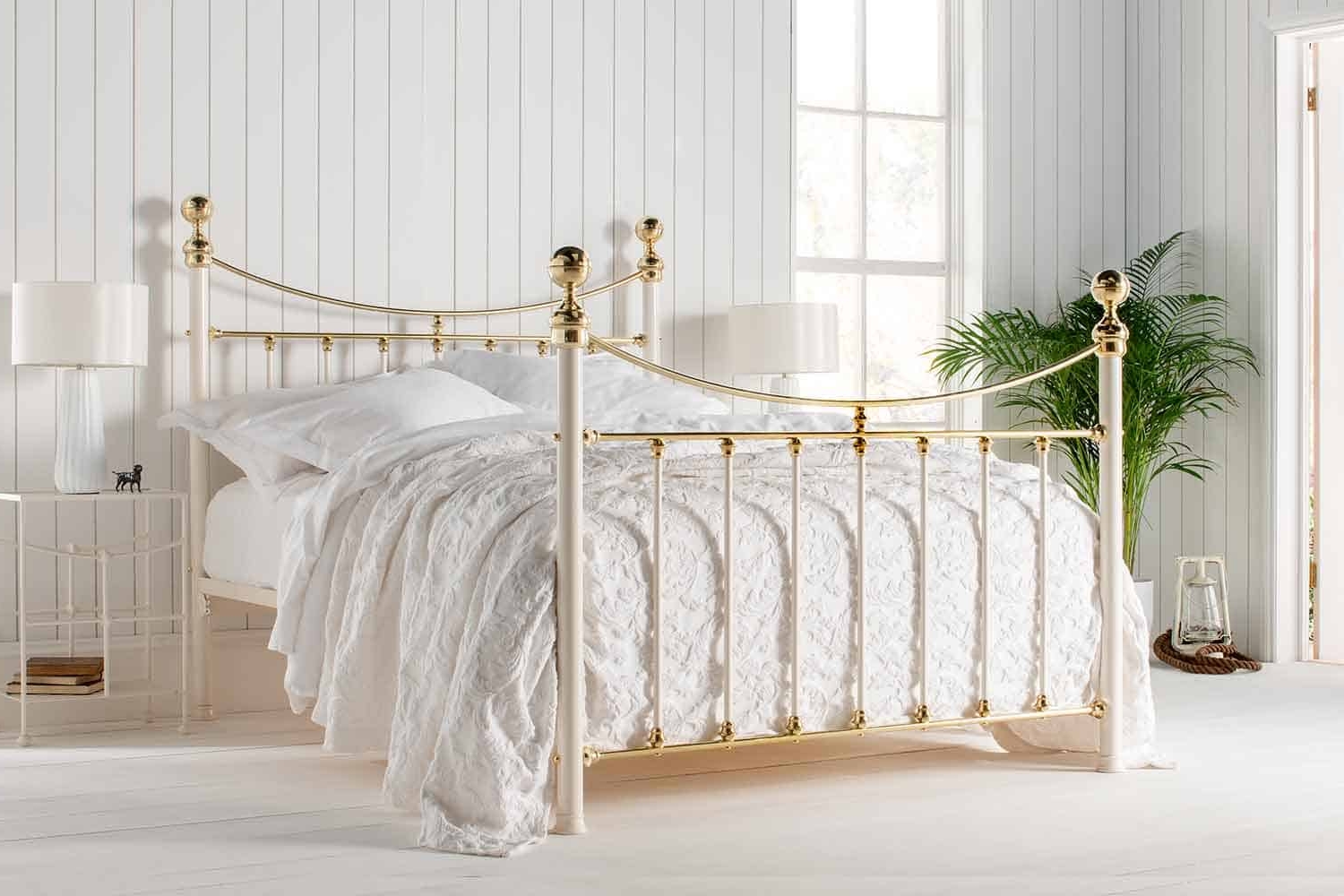 Lottie brass bed with curved headboard and white bedding in a light-filled classic bedroom
