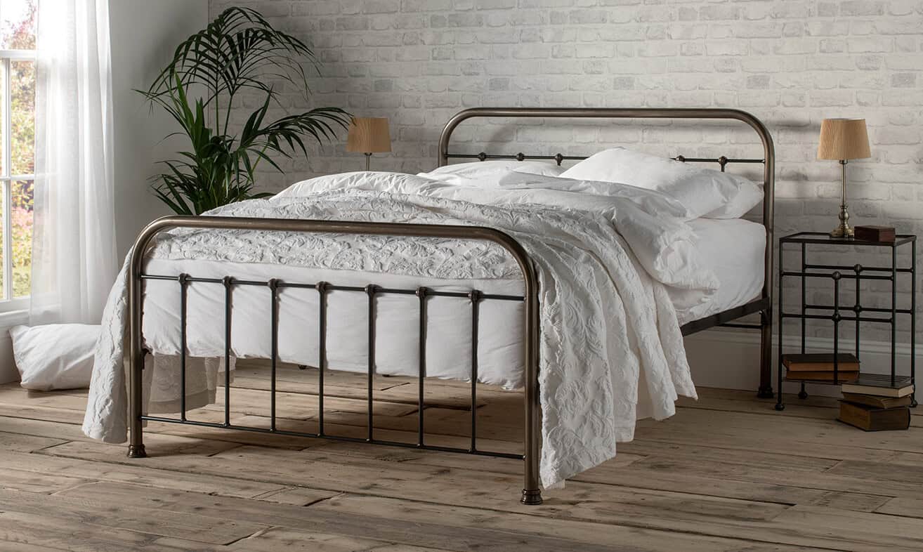 bronze dorm-style iron in a midern setting, the bed is dressed with whit bedlinen