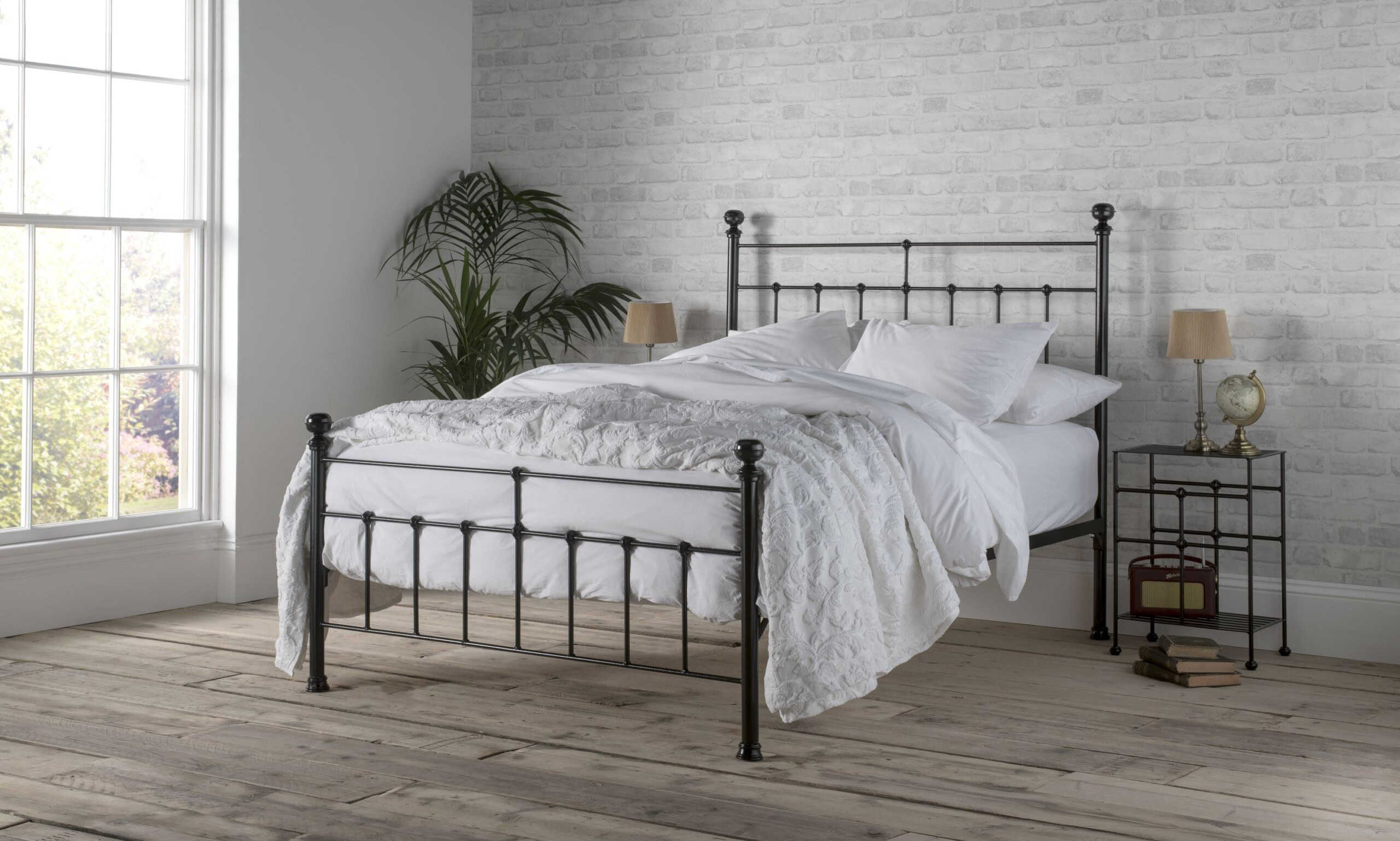 black metal bedframe in a modern chic bedroom, the metal bed is drssed in white linen