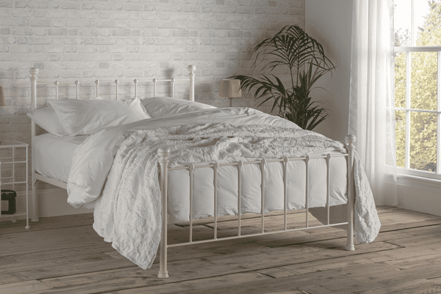 The Grace iron bed frame with soft curves and supportive slats, styled in a bright bedroom with neutral tones
