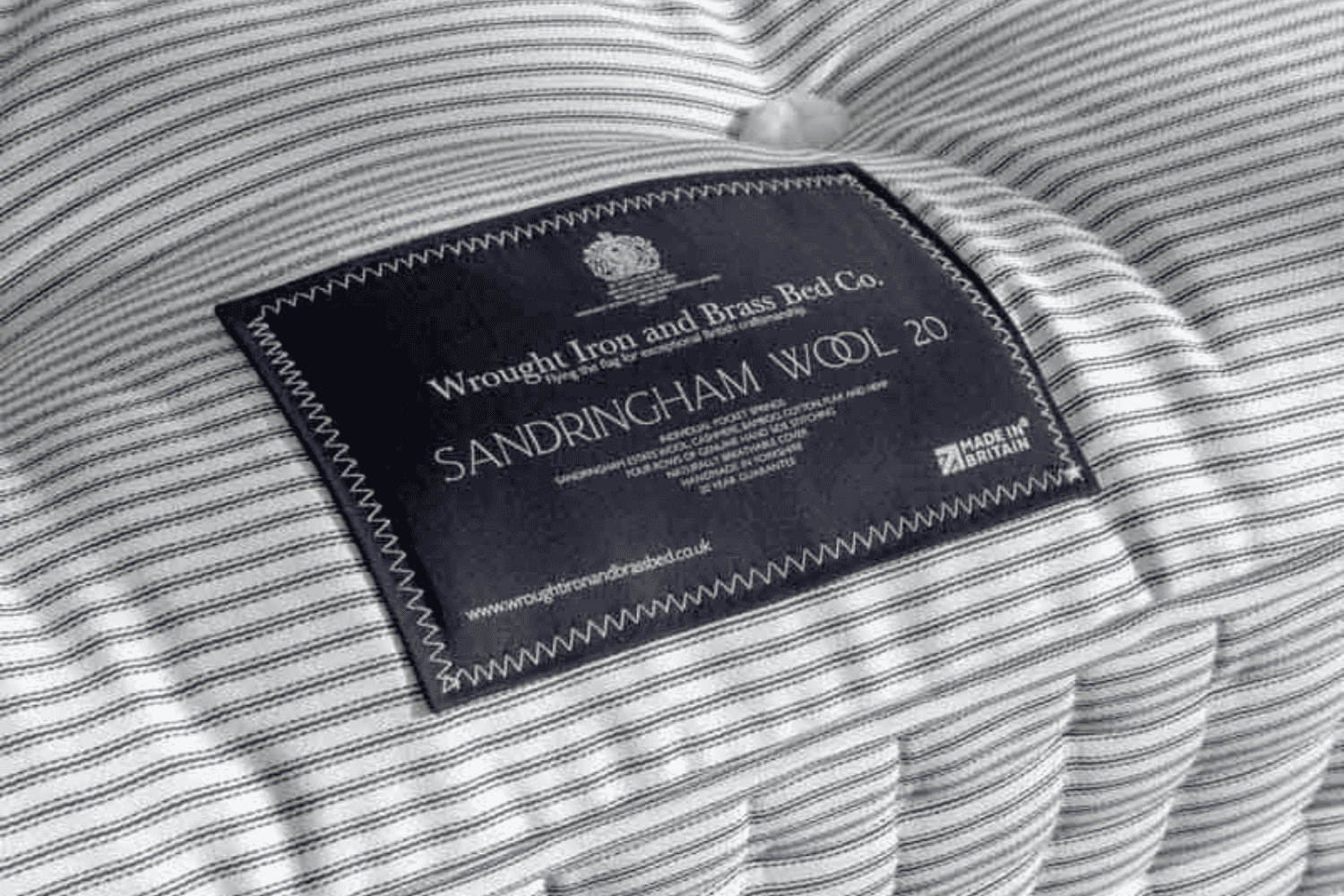 Handmade mattress label stitched onto striped ticking fabric